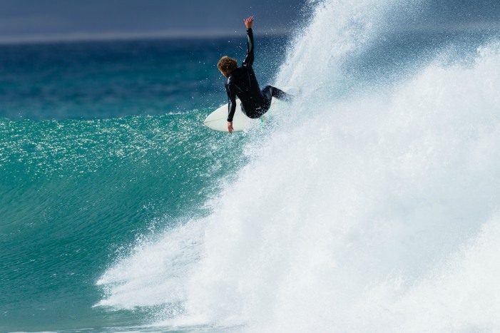 Surfero cogiendo una ola en Jeffrey's Bay, Sudáfrica.