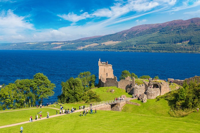El castillo de Urquhart a orillas del misterioso lago Ness en un día de verano. El El castillo de Urquhart a orillas del misterioso lago Ness en un día de verano.