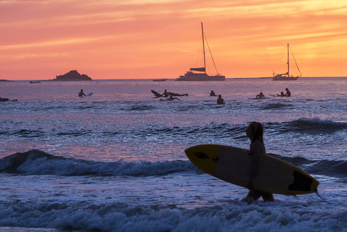 Surf al atardecer en la playa de Tamarindo, Costa Rica.