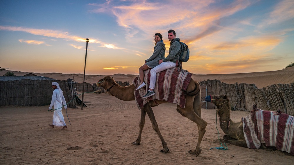 Pareja en camello en el desierto