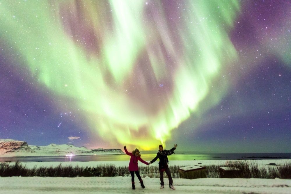 Pareja contemplando una aurora boreal en Islandia