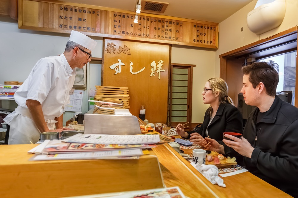 Turistas comiendo sushi en un restaurante de Tokyo