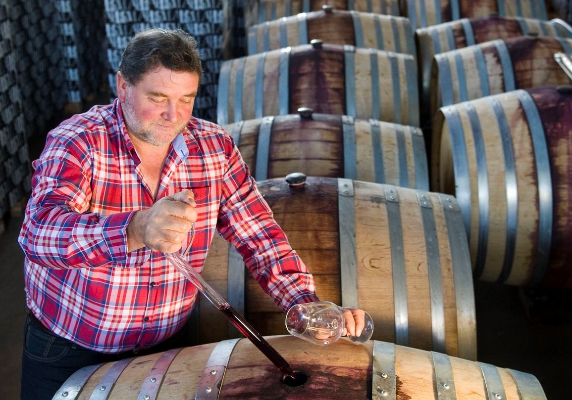 Enólogo extrayendo vino de barrica para una cata