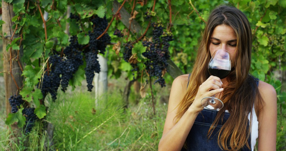 Chica catando una copa de vino tinto