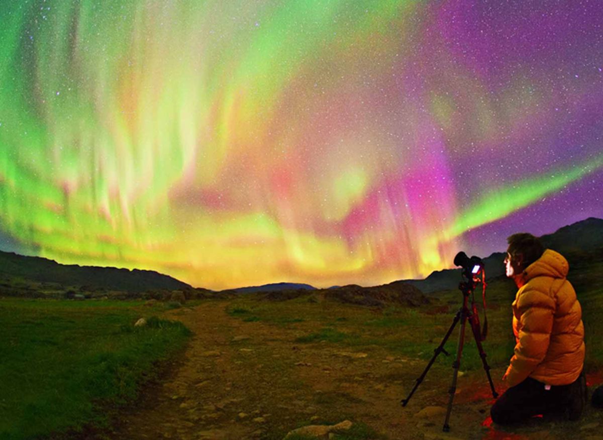 Chico fotografiando aurora boreal en Utsjoki