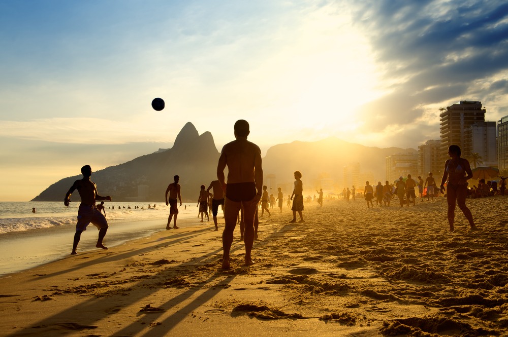 Grupo de jóvenes disfrutando del atardecer en la playa de Ipanema Beach en Rio de Janeiro