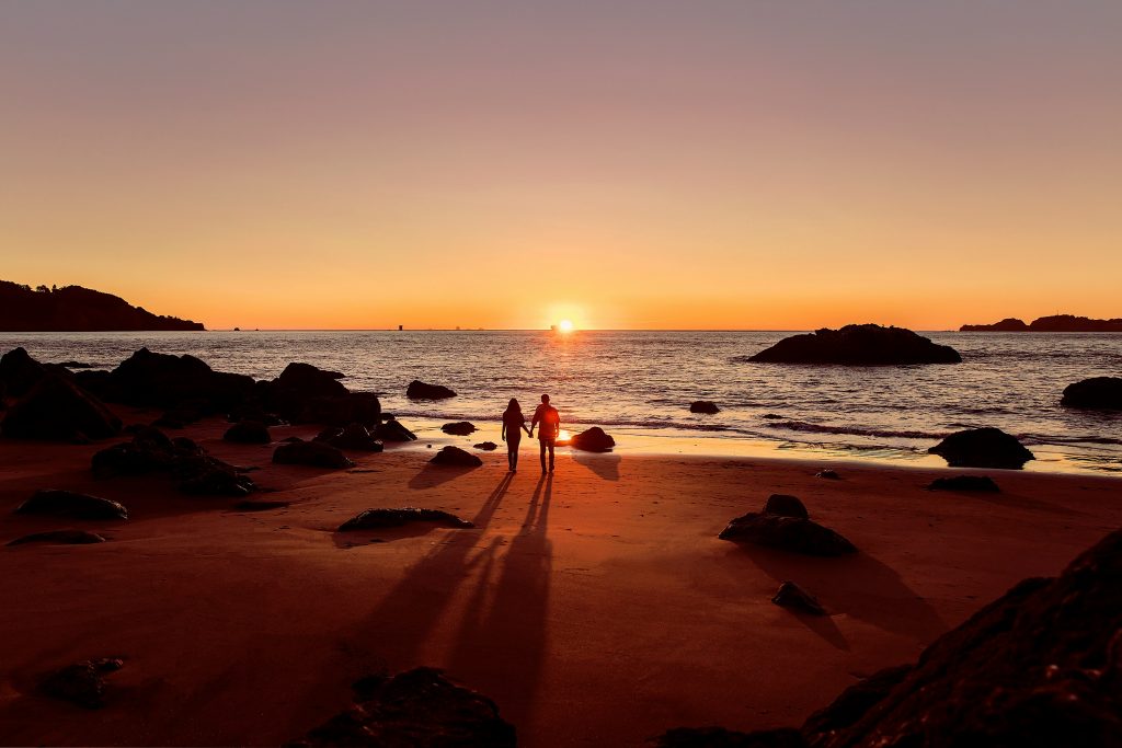 Pareja viendo la puesta de sol en su luna de miel en un destino ideal