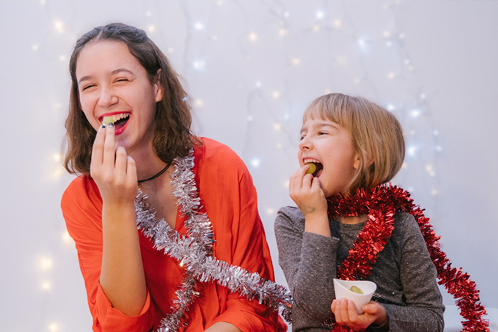 Celebración de año nuevo en España. Niñas comiendo uvas en nochevieja en España