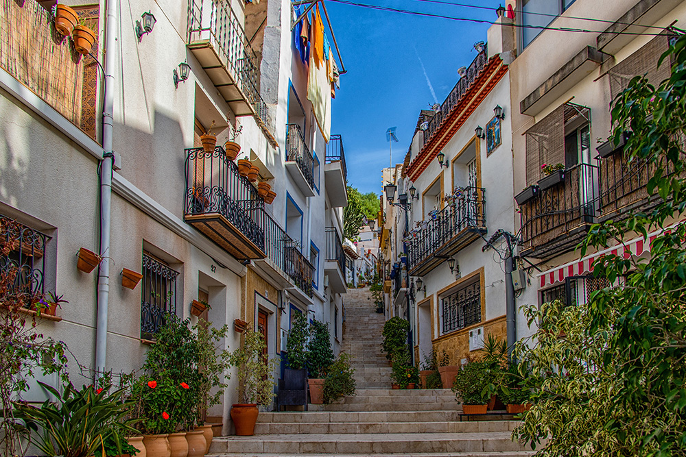 Calle del barrio de Santa Cruz. La calle esta formada por escalones en vez de asfalto y ambos lados macetas en las puertas de las casas y en los muchos balcones