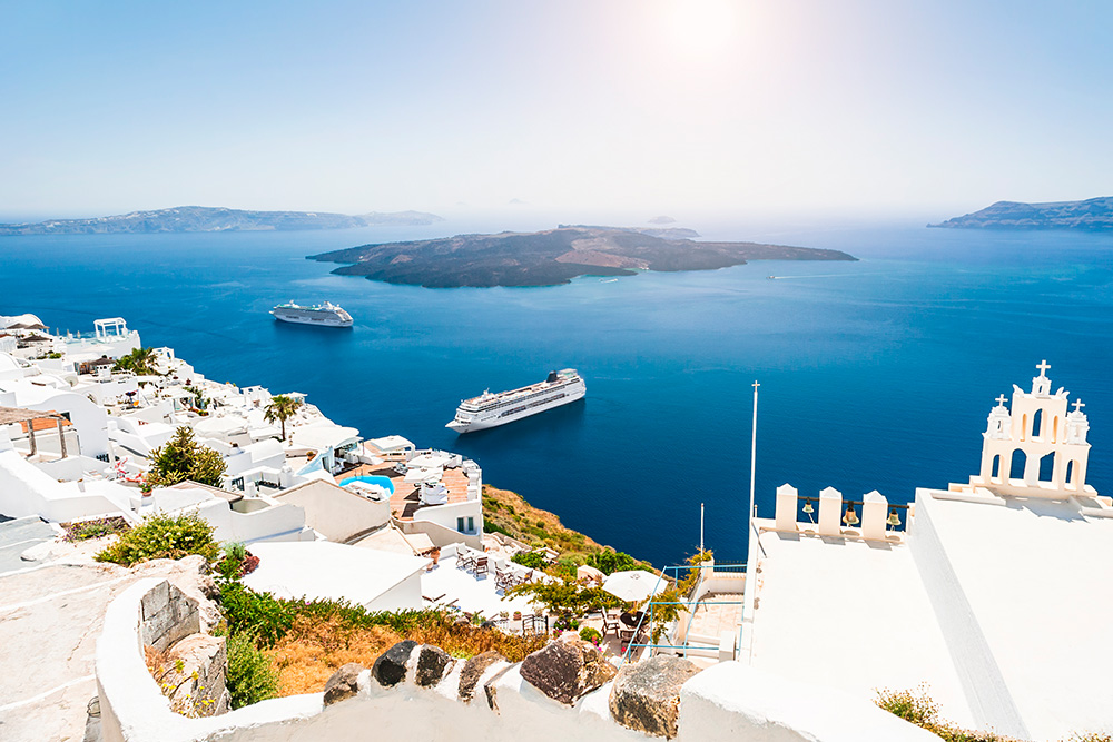 Crucero frente a una costa de edificios bajos blancos y en un mar azul