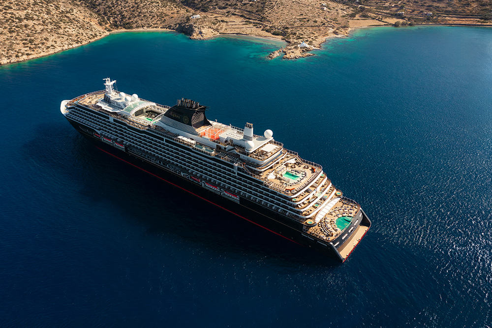 Crucero frente a una costa en un mar de azul marino.